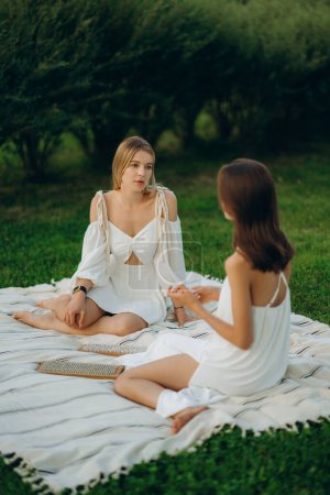 Téléchargez les photos : Méditation et clouage. Deux jeunes femmes méditent dans la nature. Photo de haute qualité - en image libre de droit