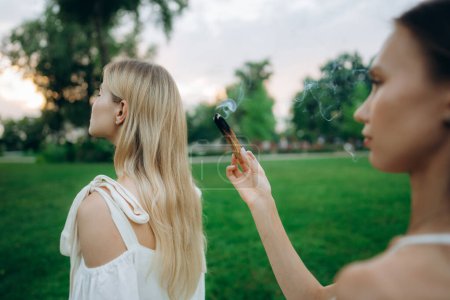 Téléchargez les photos : Une jeune femme pratique la méditation dans la nature. Méditation avec fumée. Photo de haute qualité - en image libre de droit
