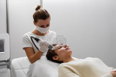 Téléchargez les photos : Un cosmétologue effectue de l'hydropilation dans un salon de beauté. Soins de la peau. Photo de haute qualité - en image libre de droit