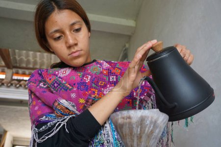 Téléchargez les photos : Guatémaltèque fille préparer le café en robe huipil traditionnelle - en image libre de droit