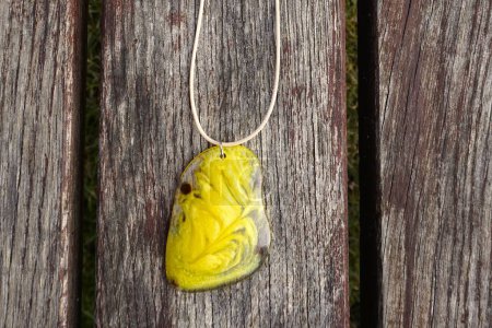 Jewelry in nature - Yellow pendant on a wooden table