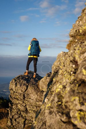 Téléchargez les photos : Femme touriste avec sac à dos trekking dans les montagnes. Randonneur a grimpé avec succès sommet de montagne. La randonnée est aventure - en image libre de droit