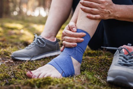 Photo for Sprain ankle during hiking in nature. Woman feeling pain after accident injury outdoors - Royalty Free Image