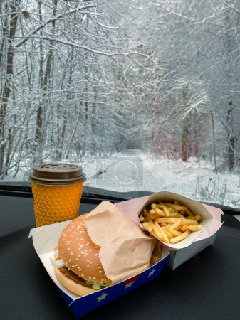 Téléchargez les photos : On dashboard of car hamburger, french fries, and coffee - en image libre de droit
