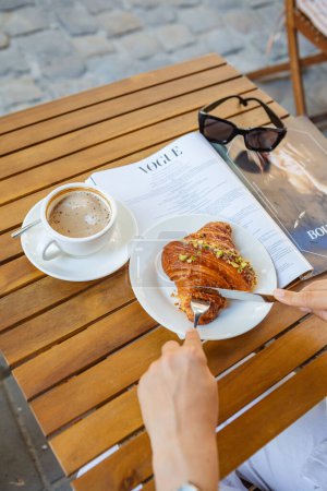 Téléchargez les photos : Petit déjeuner avec croissant, café et magazine au café - en image libre de droit