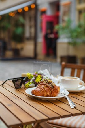 Photo for Croissant and cup of coffee on the cafes summer terrace - Royalty Free Image