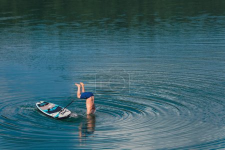 Foto de Hombre saltar de supboard en el espacio de copia de agua actividades de verano agua - Imagen libre de derechos