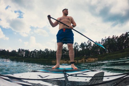 Foto de Hombre feliz en supboard remando actividades acuáticas de verano - Imagen libre de derechos