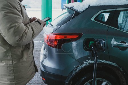 Téléchargez les photos : Gars remplit sa voiture et paie pour l'essence en utilisant le téléphone - en image libre de droit