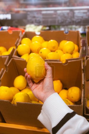 Foto de Mano tomar limón de la tienda de comestibles espacio de copia - Imagen libre de derechos