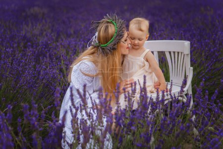 It is a picture of small girl with her mother wearing lavender wreath