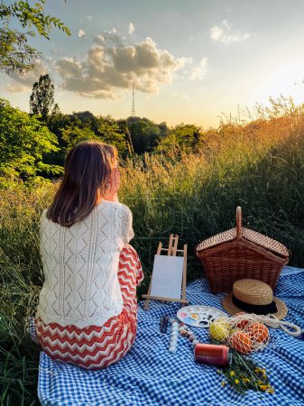 Paraíso de los pintores: la mujer crea arte durante el picnic.