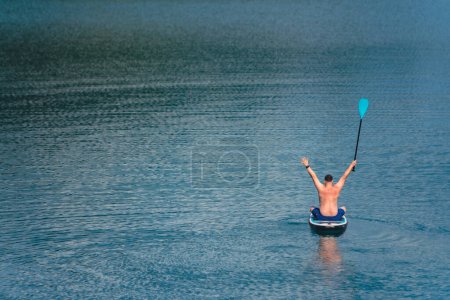 man on paddleboard in the middle of the lake copy space