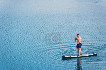 Foto de Hombre equilibrio en supboard remar en el centro de las actividades acuáticas del lago - Imagen libre de derechos