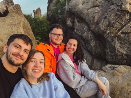 Téléchargez les photos : Amis heureux de prendre selfie au coucher du soleil sur le sommet de la falaise heure d "été - en image libre de droit