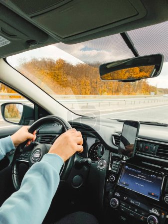 Téléchargez les photos : Concept road trip homme conduite voiture par autoroute vue de l'intérieur automne saison - en image libre de droit