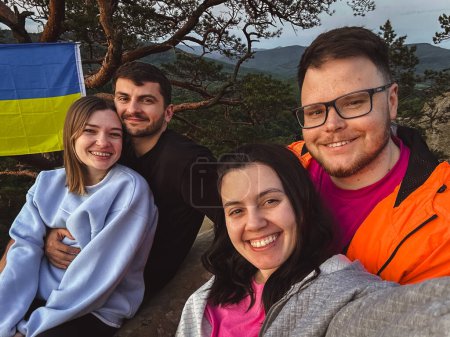 Téléchargez les photos : Amis heureux de prendre selfie au coucher du soleil sur le sommet de la falaise heure d "été - en image libre de droit