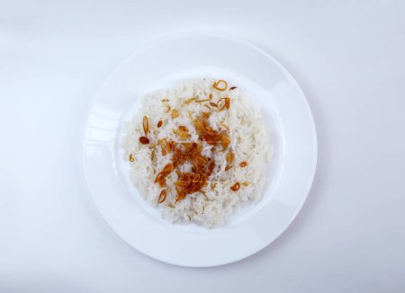 Foto de Vista superior de un plato de arroz blanco caliente cubierto con cebollas fritas. Concepto para comida asiática de confort. - Imagen libre de derechos