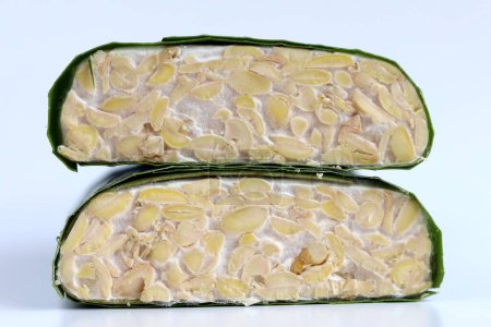 Foto de Una rebanada de tempeh o tempe crudos, alimentos tradicionales indonesios hechos de soja fermentada, aislados sobre fondo blanco - Imagen libre de derechos