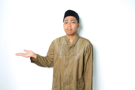 Photo for Asian muslim man presenting to beside with stressed expression isolated on white background - Royalty Free Image
