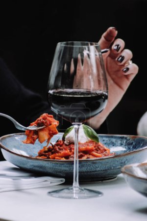 Foto de Primer plano de las manos de mujer sosteniendo pimienta negra con salsa de tomate y vino tinto - Imagen libre de derechos