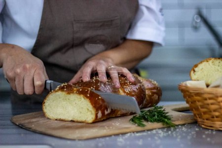 Foto de Chef cortando pan con queso y cuchillo - Imagen libre de derechos