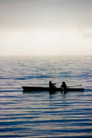 Foto de Silueta de un hombre con un barco en el lago - Imagen libre de derechos