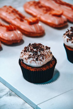 Foto de Cupcakes de chocolate con crema y café sobre fondo blanco - Imagen libre de derechos