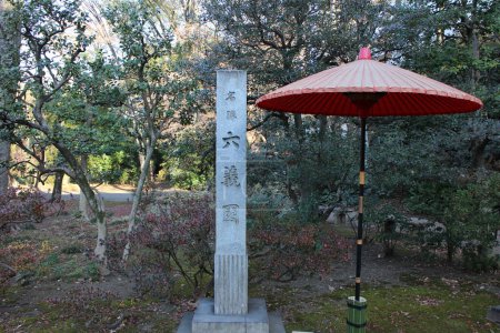 Téléchargez les photos : Monument en pierre et parapluie traditionnel dans le jardin Rikugien, Tokyo, Japon (mots japonais signifiant le nom du jardin "Rikugien") - en image libre de droit