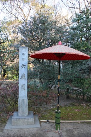 Stone monument and traditional umbrella in Rikugien Garden, Tokyo, Japan (Japanese words mean the name of garden "Rikugien")