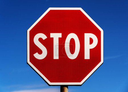 Téléchargez les photos : Panneau routier octogonal d'arrêt sur un ciel bleu - en image libre de droit