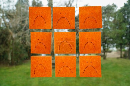 Téléchargez les photos : 9 oranges postent son avec des visages tristes stock sur une fenêtre - en image libre de droit