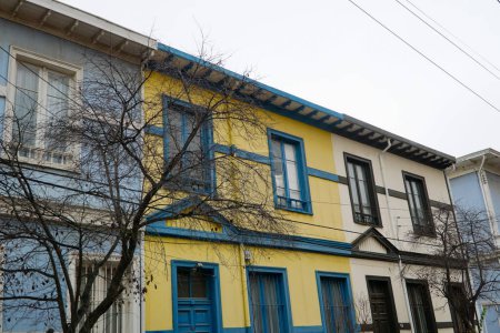 Téléchargez les photos : Vue imprenable sur trois charmantes maisons en rangée colorées nichées dans les collines de Valparaso. - en image libre de droit