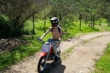 Ein Teenager fährt mit dem Motorrad durch eine sonnenbeschienene Sommerlandschaft, die warme Brise und endlose Felder schaffen eine perfekte Kulisse für Abenteuer.