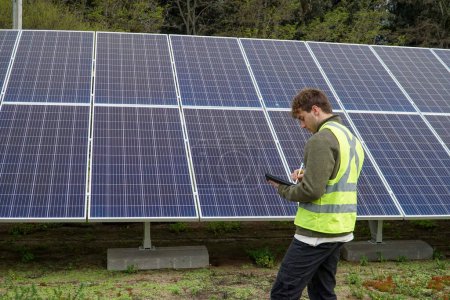 Foto de Un profesional uniformado trabajando con paneles solares en un bosque en Chile. - Imagen libre de derechos
