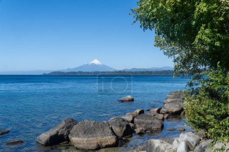 Sommer-Blick auf einen ruhigen See und einen Vulkan im Hintergrund