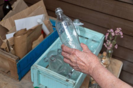 Älterer Mensch recycelt eine Plastikflasche