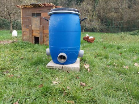 Photo for Homemade automatic feeder for chickens. feeding the roosters in the chicken coop in the backyard garden - Royalty Free Image