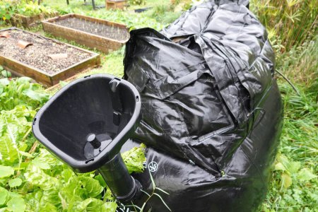 Téléchargez les photos : Biodigesteur en fonctionnement dans un jardin. entonnoir pour mettre dans la matière organique et courir sur le biogaz. - en image libre de droit