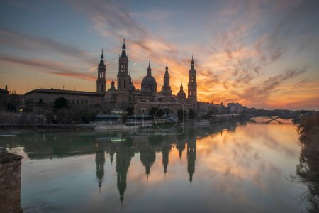Photo for Del Pilar basilica, one of the important architectural symbols of zaragoza, and the Ebro river and its reflection with sunset colors and clouds - Royalty Free Image