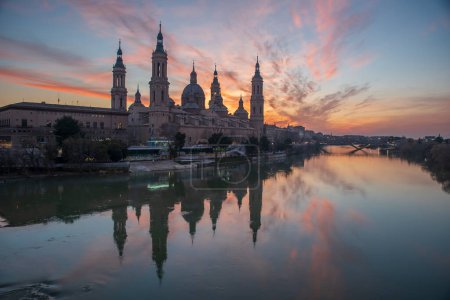 Photo for Del Pilar basilica, one of the important architectural symbols of zaragoza, and the Ebro river and its reflection with sunset colors and clouds - Royalty Free Image