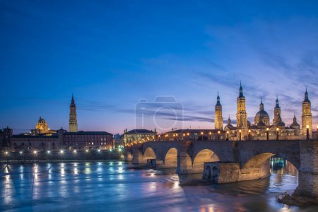 Del Pilar basilica, one of the important architectural symbols of zaragoza, and the Ebro river and its reflection with sunset colors and clouds