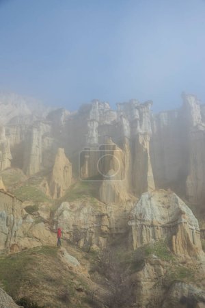 Foto de Región de Kuladocia, formada por restos volcánicos y erosión durante siglos, en el distrito de Kula de Manisa, donde una persona sola viaja en un día de niebla. - Imagen libre de derechos