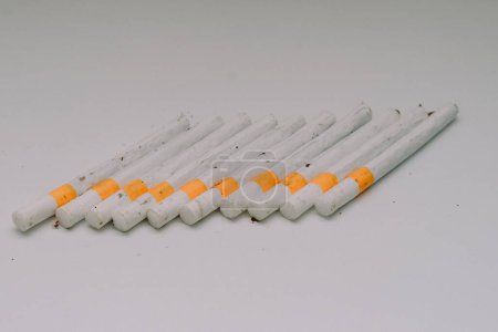 Téléchargez les photos : Plusieurs cigarettes kretek alignées sur une base blanche - en image libre de droit