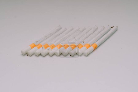 Photo for Several kretek cigarettes lined up on a white base - Royalty Free Image