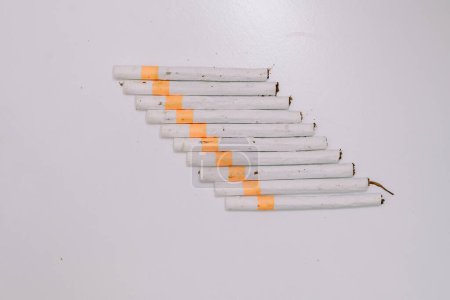 Téléchargez les photos : Plusieurs cigarettes kretek alignées sur une base blanche - en image libre de droit