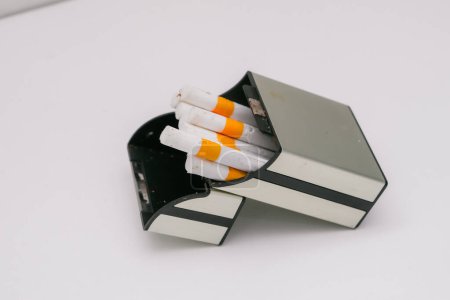 Foto de Varios cigarrillos y su embalaje de plástico resistente muestran la elegancia de un cigarrillo - Imagen libre de derechos