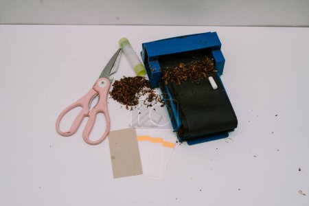 a cigarette rolling tool consisting of a pipe, scissors, papier paper and paper glue