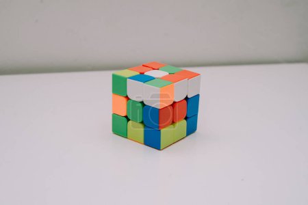 Photo for An unsolved 3x3 Rubik's cube stands on a white base - Royalty Free Image