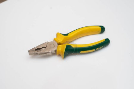 a yellow pair of pliers is placed on a white base
